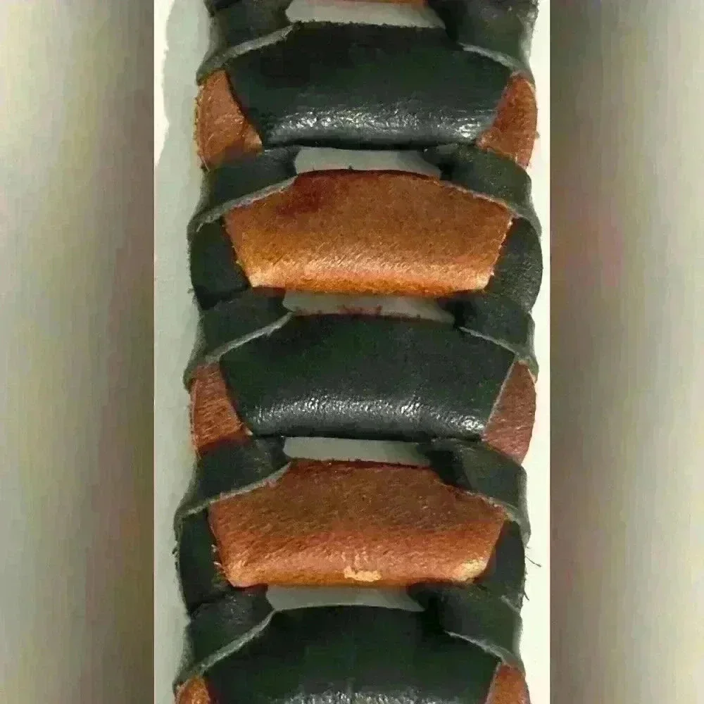A men’s braided link dress belt with a brass buckle.